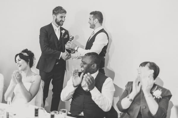 Best man handing groom gift