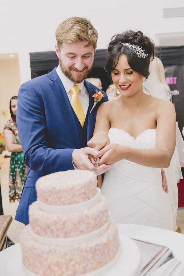 Bride and groom cutting wedding cake