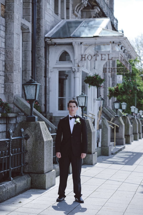 Retro groom outside Duke of Cornwall Hotel