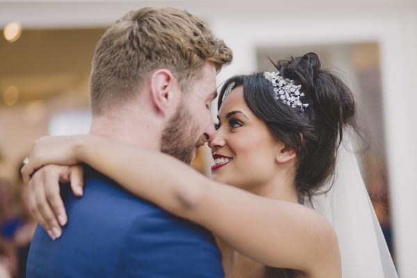 Bride and groom looking into each others eyes on dance floor.