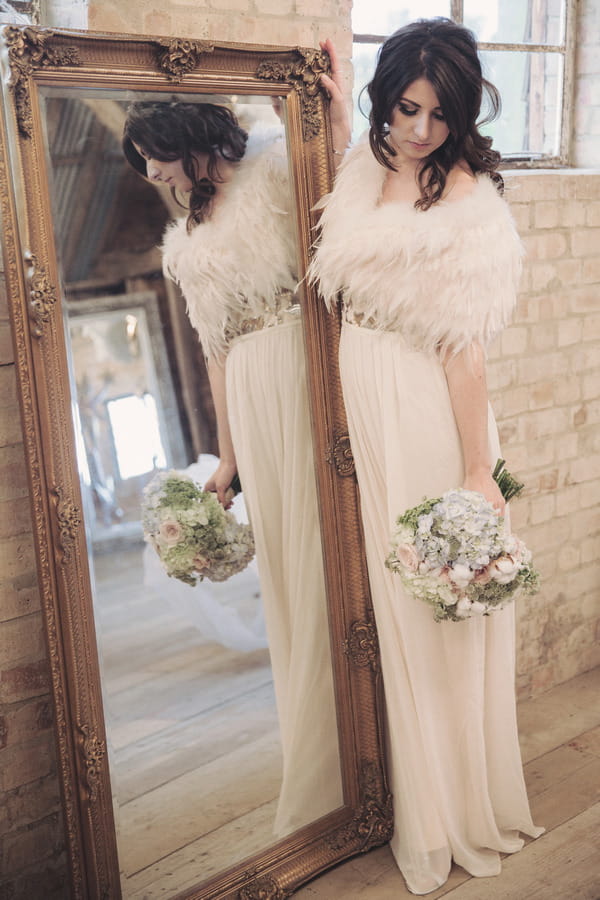 Bride holding bouquet next to mirror