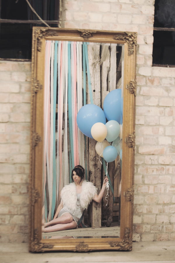 Reflection in mirror of bride sitting on floor