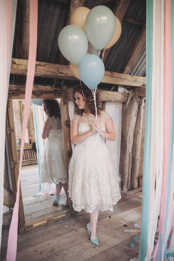 Bride holding balloons in front of mirror