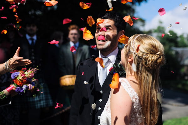 Bride and groom under confetti shower