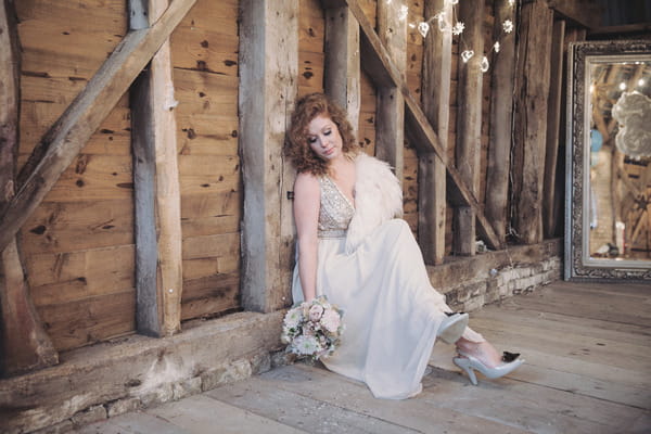 Bride sitting on floor of barn