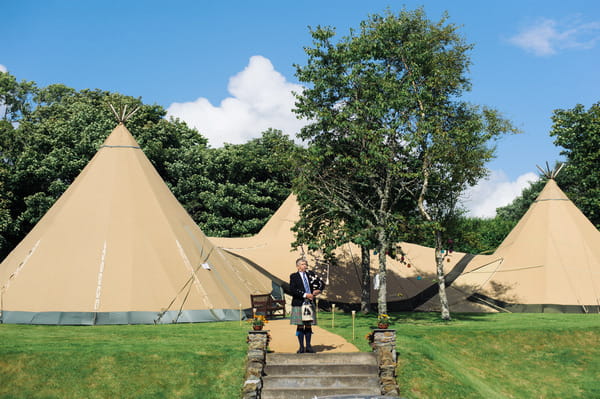 Bagpiper in front of tipis