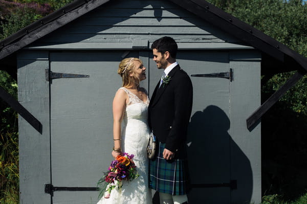 Bride and groom in front of shed