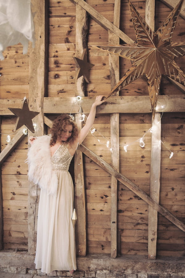 Bride standing up against barn wall