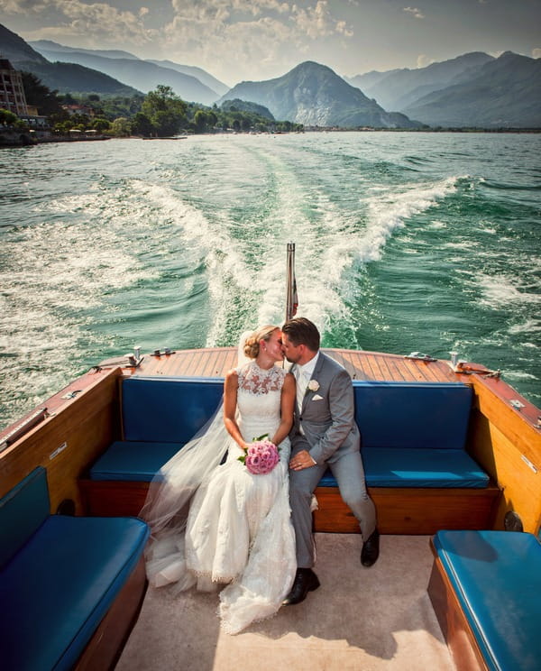 Bride and groom kissing on speedboat