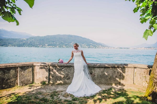Bride leaning against wall by Lake Maggiore, Italy