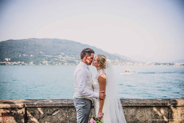 Bride and groom kissing by Lake Maggiore, Italy