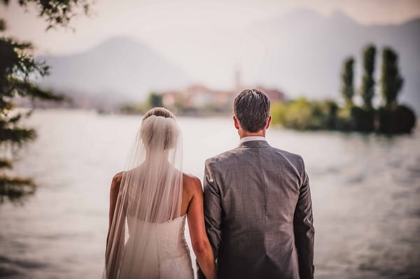 Bride and groom standing side by side by Lake Maggiore, Italy