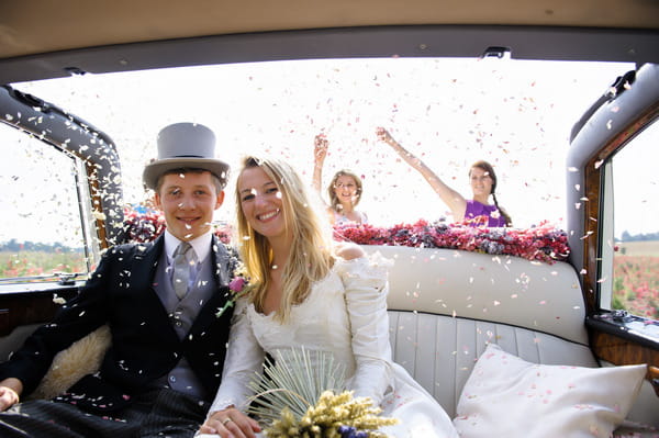 Wedding Guests Throwing Confetti from Shropshire Petals Over Couple in Car