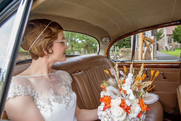 Bride in back of wedding car