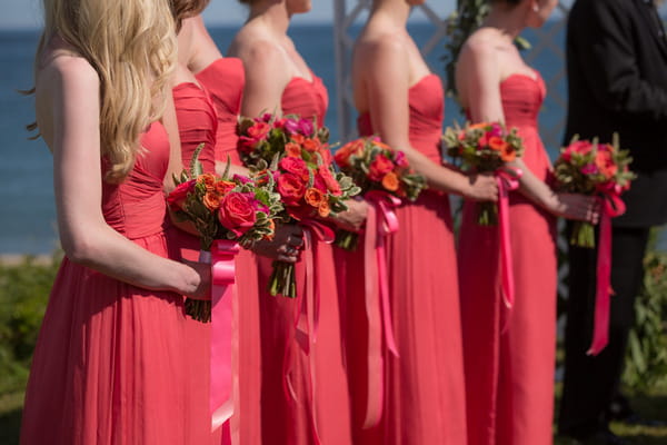 Bridesmaids in pink dresses holding colourful bouquets