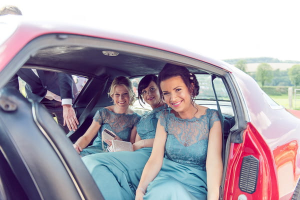 Bridesmaids in back of Pontiac Firebird