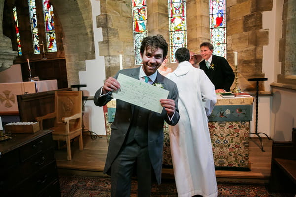 Groom holding marriage certificate