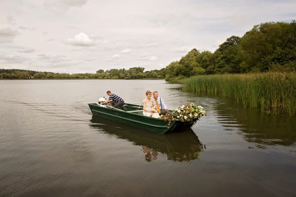 Bride and groom in boat on lake