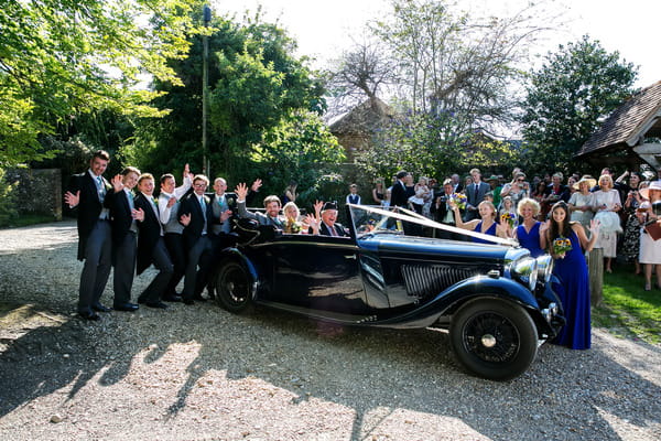 Bride and groom in vintage Bentley wedding car