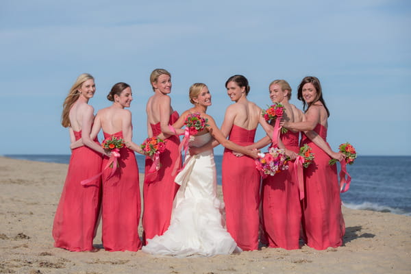 Bride and bridesmaids standing in row with back to camera