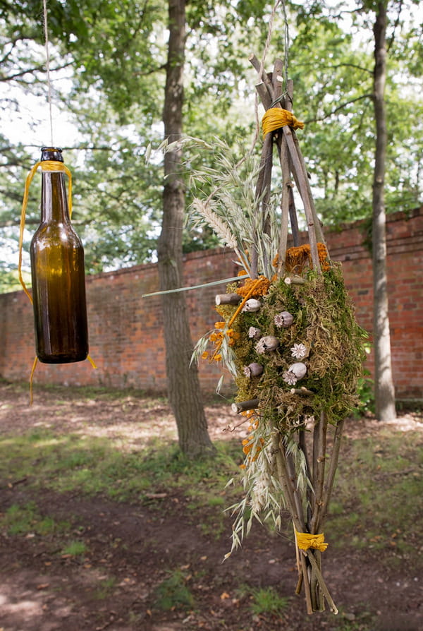 Beer bottles and rustic flowers hanging from tree