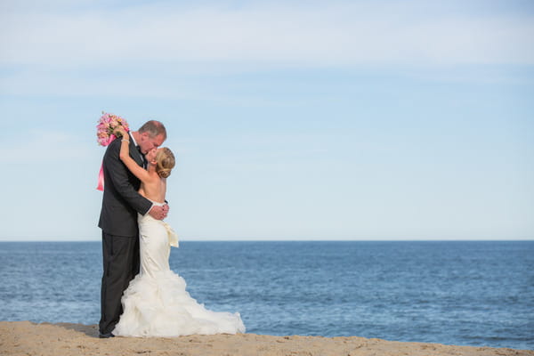 Bride and groom kiss by sea on Nantucket Island