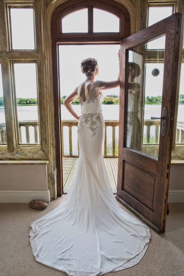 Bride standing in doorway overlooking lake