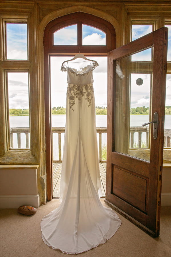 Harlem wedding dress by Enzoani, hanging in doorway