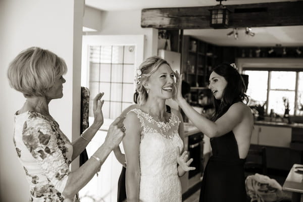 Bridesmaids and mother helping bride get ready