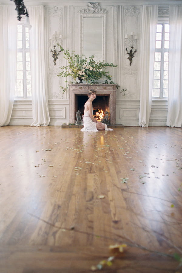 Bride kneeling next to fireplace