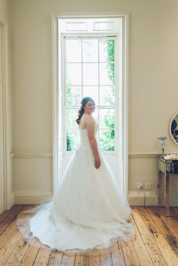 Bride standing in front of window