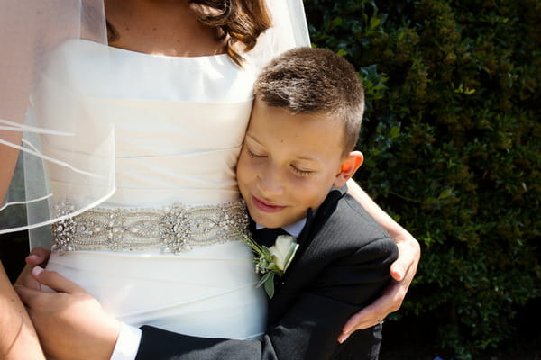 Boy hugging mum on her wedding day
