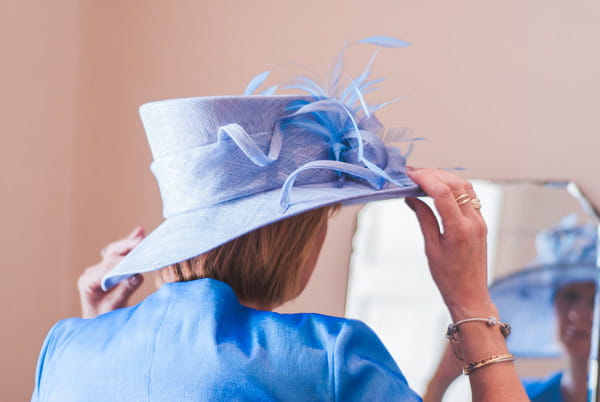 Bride's mother putting on hat