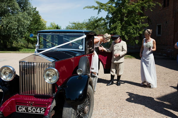 Bride getting out of classic wedding car