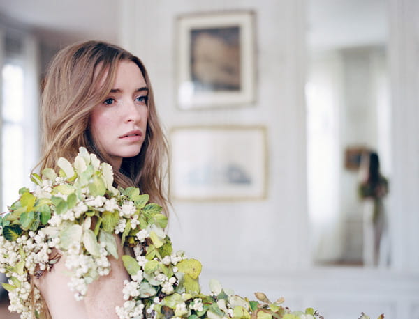 Bride with flower and leaf wreath over shoulder