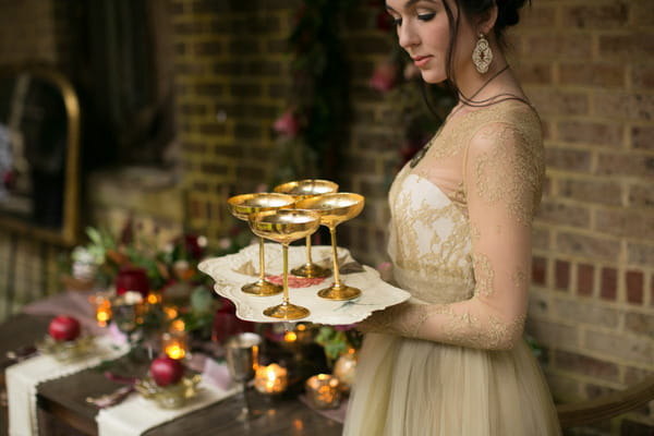 Bride holding tray of gold cups