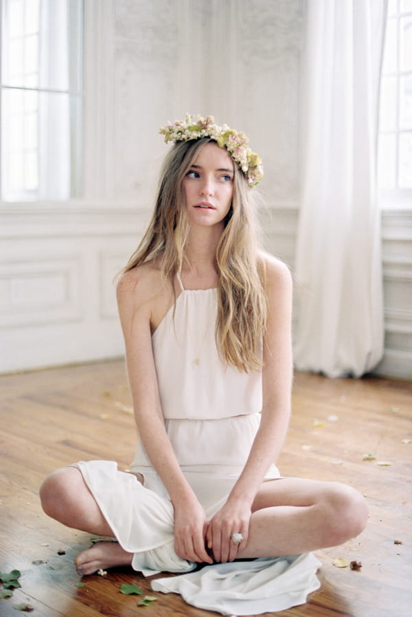 Bride with flower crown sitting with legs crossed