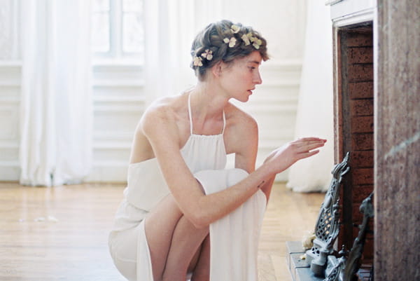 Bride with flower headband crouching by fire