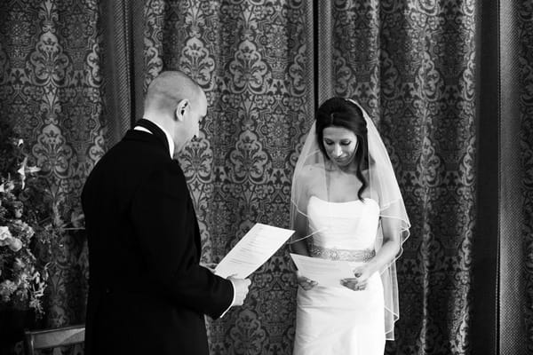 Bride and groom reading wedding vows