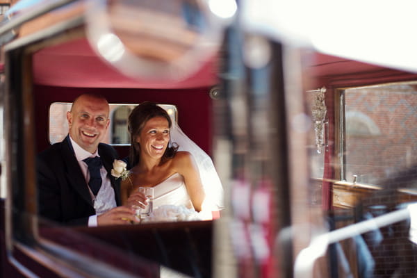 Bride and groom in back of wedding car