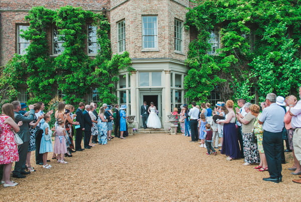 Bride and groom walking out of Narborough Hall