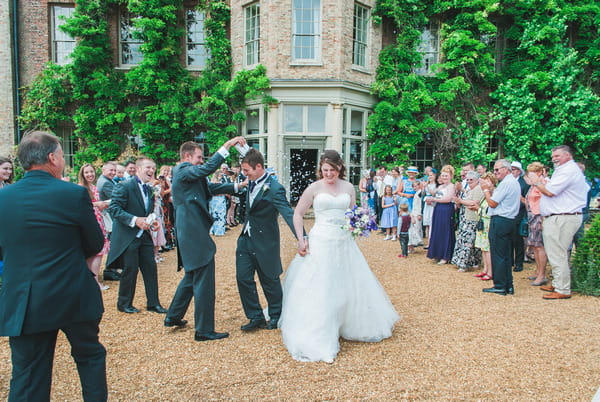 Groomsman throwing confetti over groom