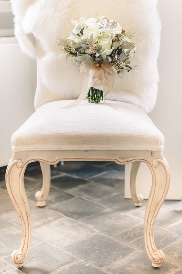 Elegant chair with wedding bouquet on seat