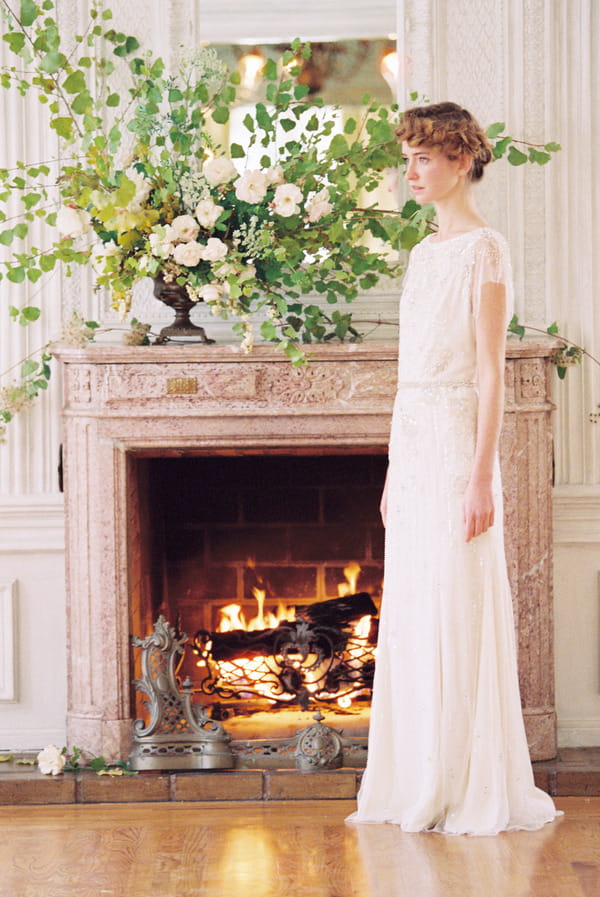 Bride standing by fireplace