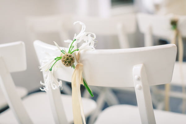 Small flower tied to back of wedding chair