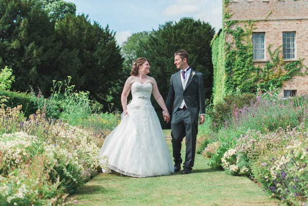 Bride and groom walking around Narborough Hall Gardens