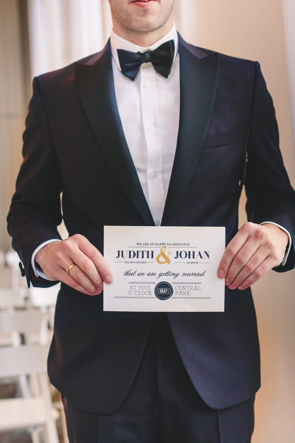 Groom holding wedding invitation