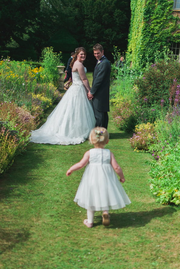 Flower girl running to bride and groom