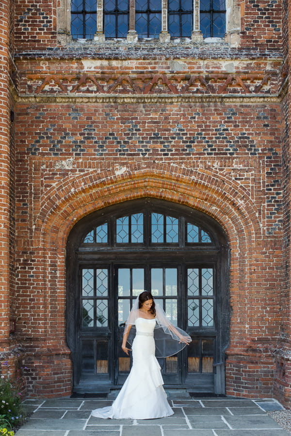 Bride standing in front of window at Layer Marney Tower