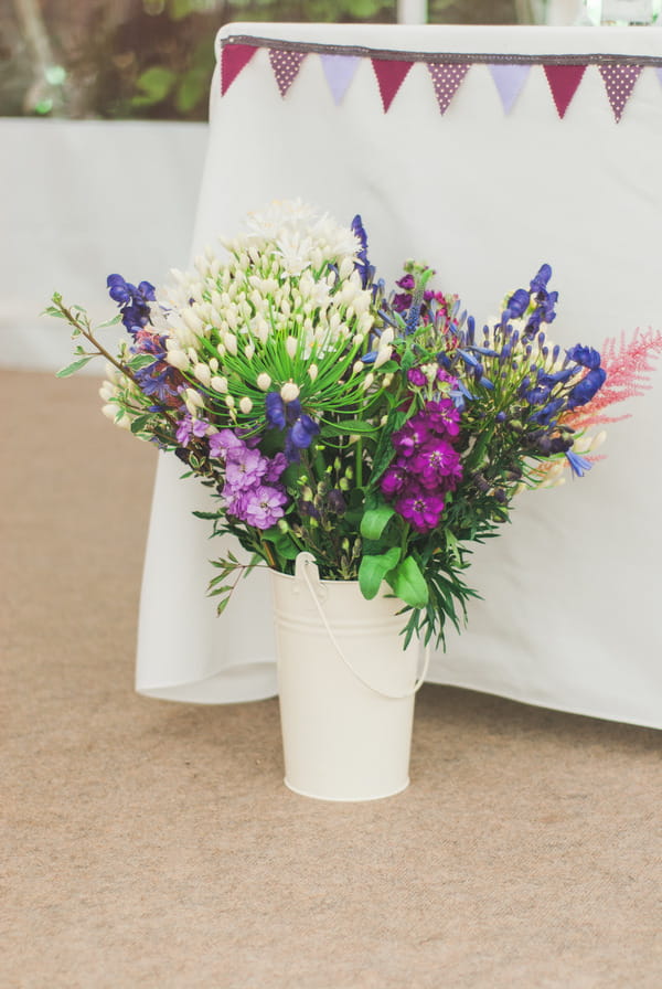 Purple flowers by wedding table